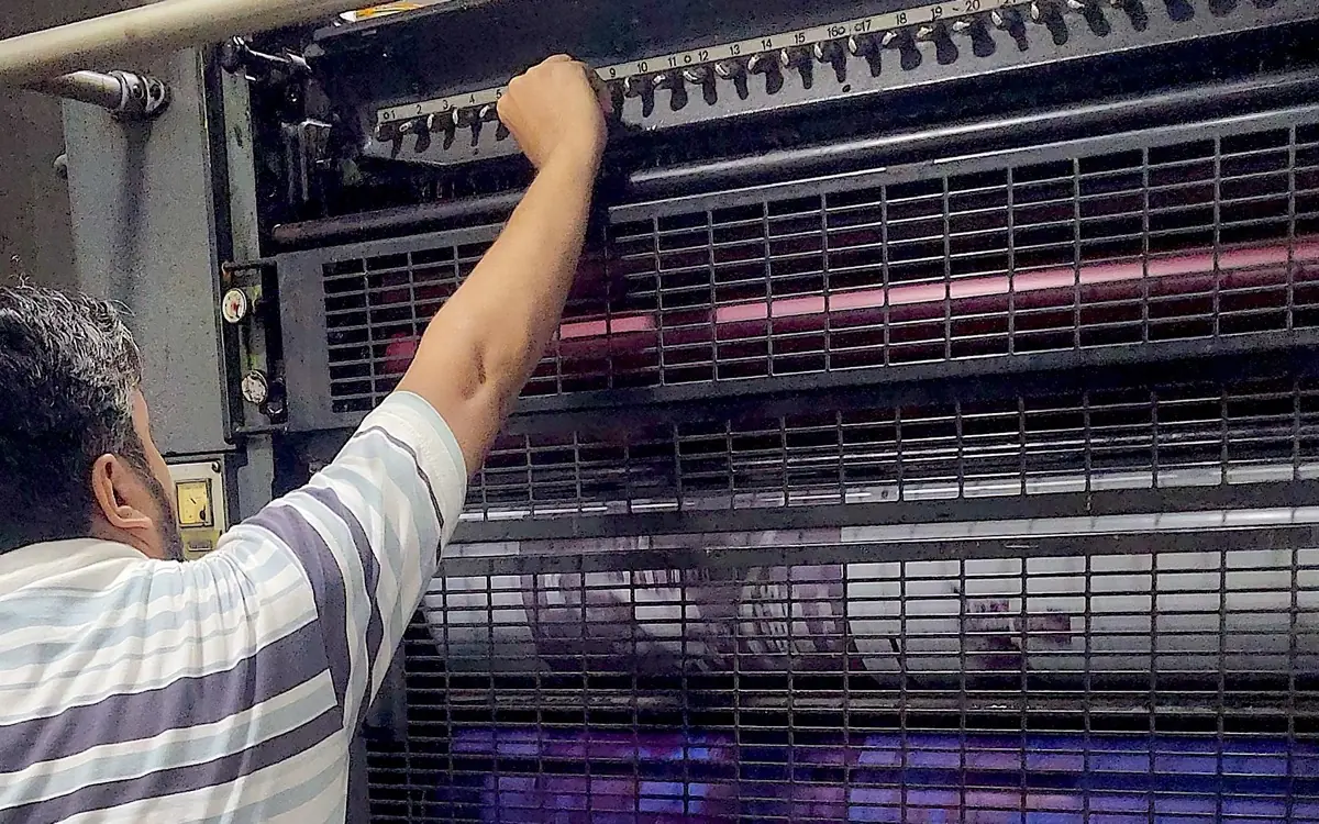 An operator adjusting the inking unit of an offset press at Talal Publishers