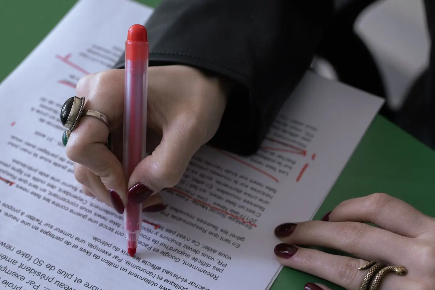 An editor marking corrections on a printed proof with a red pen